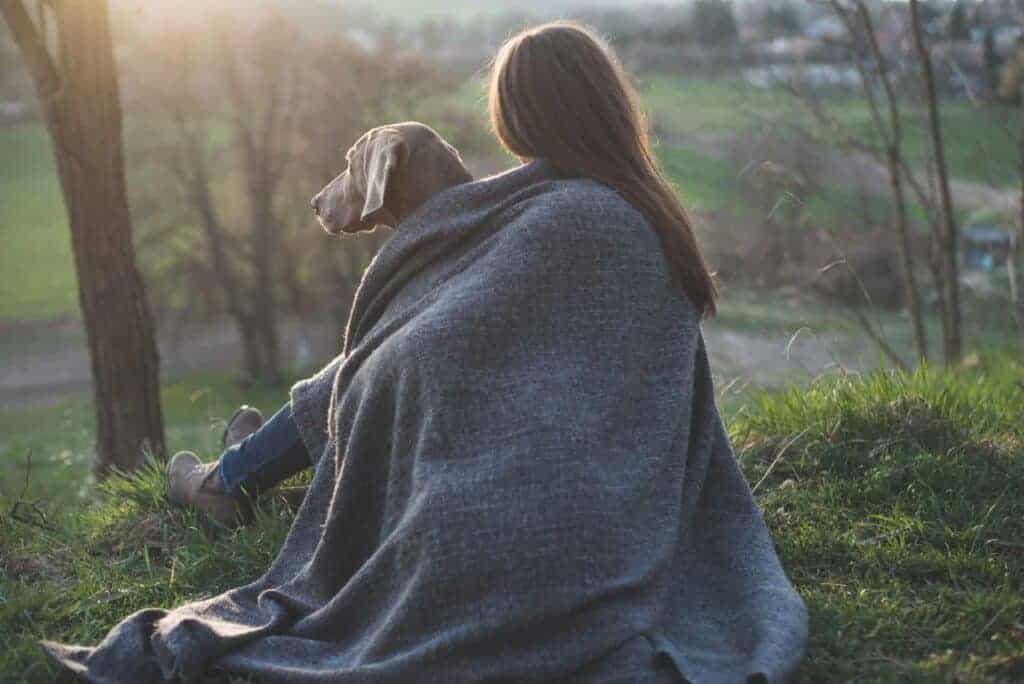 Frau mit schönem Hund im Freien liegend